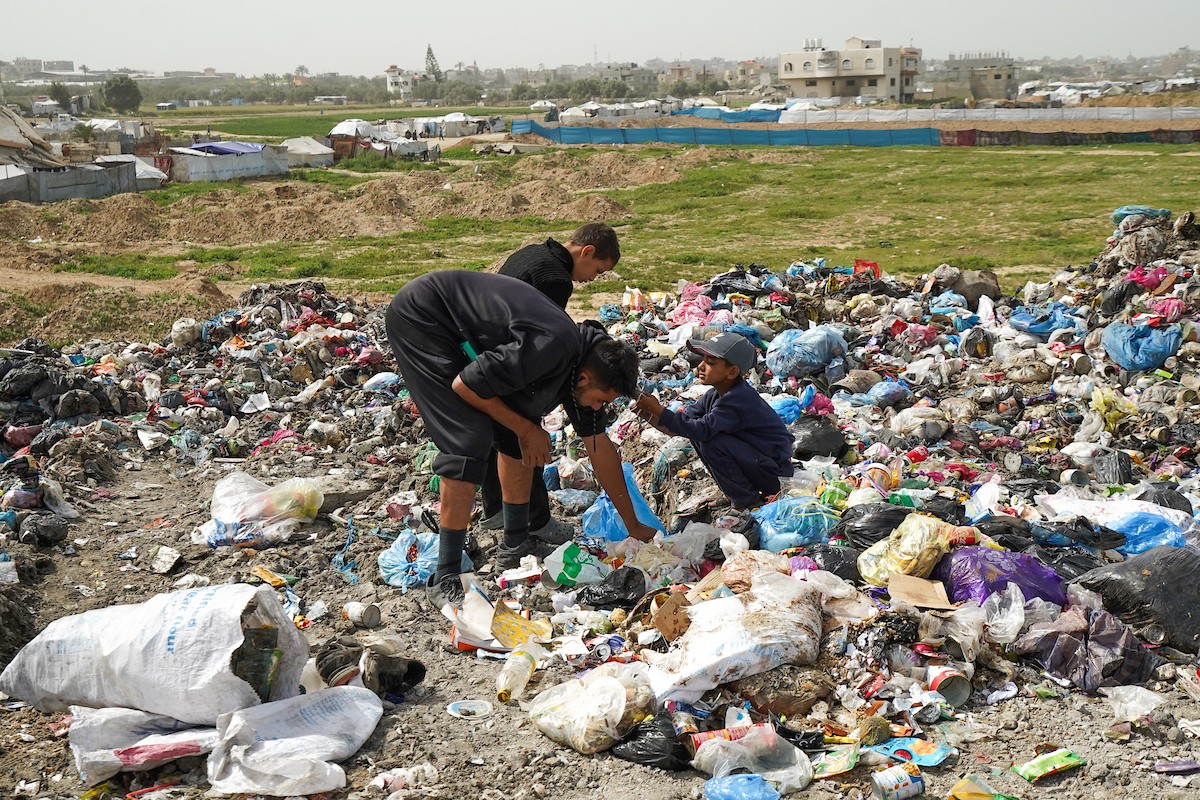 أطفال فلسطينيون يبحثون بين أكوام القمامة عن بقايا الطعام أو الألعاب في مكب نفايات بمخيم البريج للاجئين وسط قطاع غزة، في 4 أبريل/نيسان 2026، بالتزامن مع يوم الطفل الفلسطيني.(صورة: رمزي أبو عامر)