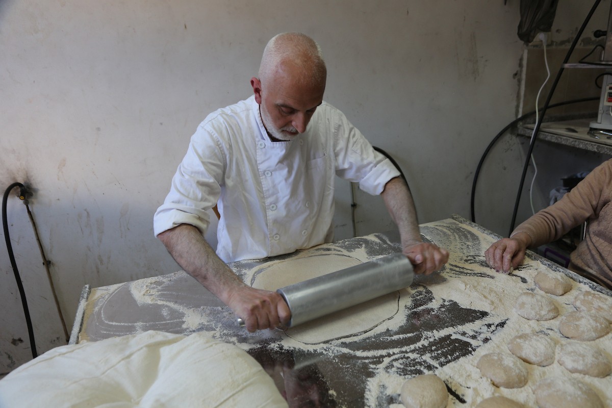 في 29 أبريل/نيسان 2026، عائلات سامرية تُعد خبز طري لطقوس ذبح الأضاحي في عيد الفصح على جبل جرزيم، المطل على مدينة نابلس في الضفة الغربية. ويعيش نحو 700 سامري بين مدينة نابلس في الضفة الغربية ومدينة حولون جنوب تل أبيب. (صورة: محمد ناصر)