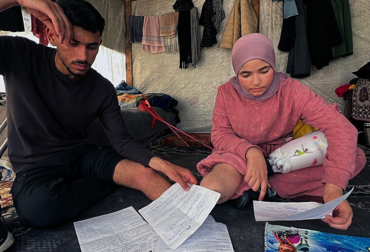 منة وائل عاشور (12 عاماً) وشقيقها فايز (24 عاماً) يعيشان في خيمة نزوح بمدينة دير البلح وسط قطاع غزة، بعد أن فقدا أطرافهما جراء هجوم إسرائيلي قبل نحو تسعة أشهر، 16 أبريل/نيسان 2026. صورة: يوسف أبو طفة