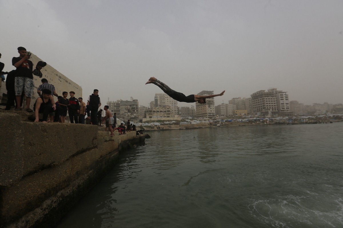 يقضي أطفال فلسطينيون أوقاتهم على شاطئ  غزة، باحثين عن ملاذ من حرارة الشمس وضغوط الحياة اليومية، في ظلّ الظروف الإنسانية المتردية التي يواجهها سكان القطاع جراء الحرب الدائرة، 17 أبريل/نيسان 2026. تصوير: بلال أسامة