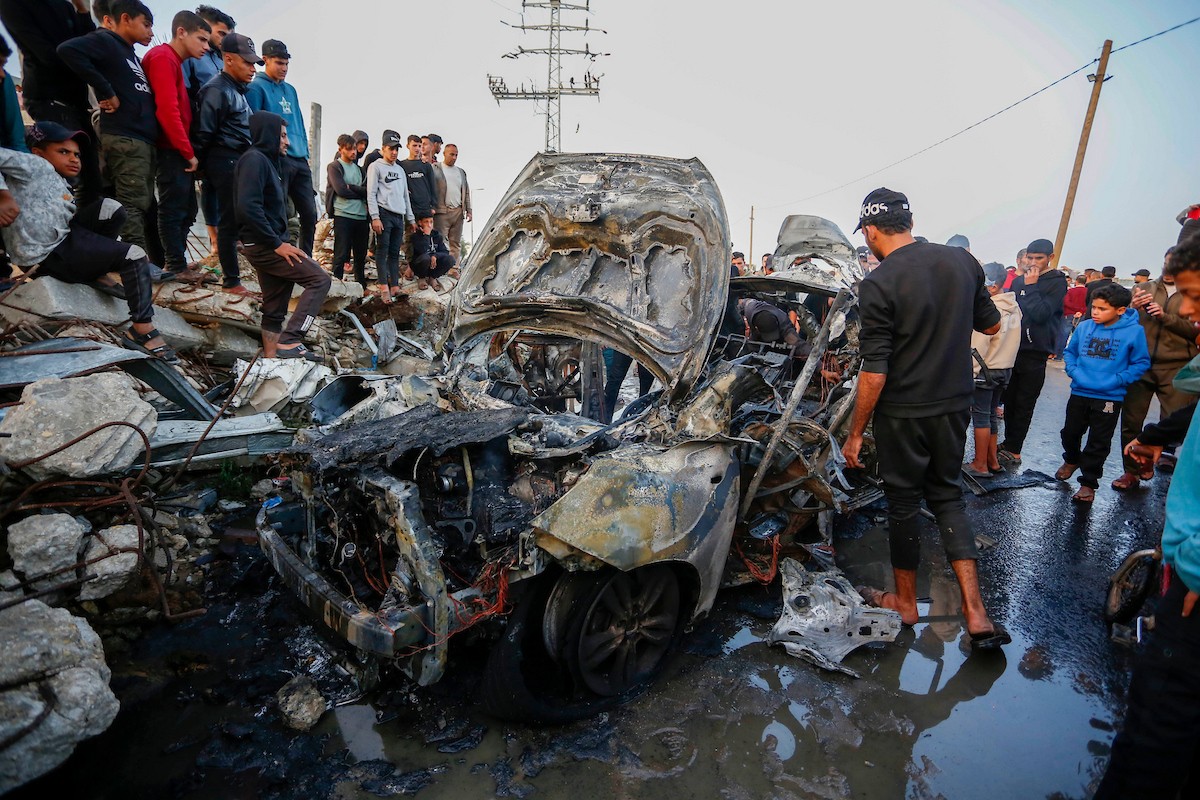 يتفقد فلسطينيون آثار غارة جوية إسرائيلية استهدفت مركبة في شارع صلاح الدين قرب مدخل مخيم المغازي للاجئين وسط قطاع غزة، في 4 أبريل/نيسان 2026.  (صورة: أحمد إبراهيم)