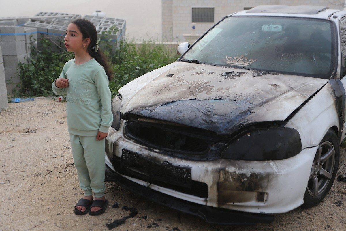 يقف فلسطينيون وسط آثار الدمار في قرية عورتا جنوب نابلس شمال الضفة الغربية، عقب هجوم نفذه مستوطنون إسرائيليون استهدف مركبات ومنازل المواطنين، مخلّفًا أضرارًا واسعة، وفق شهود عيان. 17 أبريل/نيسان 2026. تصوير: محمد ناصر.