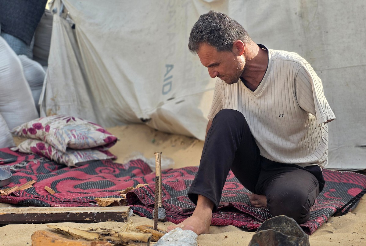 الفلسطيني محمد النواجة، الذي بُترت يده اليسرى في غارة إسرائيلية أثناء فراره من النزوح، يجلس داخل خيمة مهترئة في خان يونس جنوب قطاع غزة، في 18 مايو/أيار 2026، آملاً في الحصول على علاج خارج القطاع وطرف صناعي يساعده على مواصلة حياته. الصورة: طارق محمد