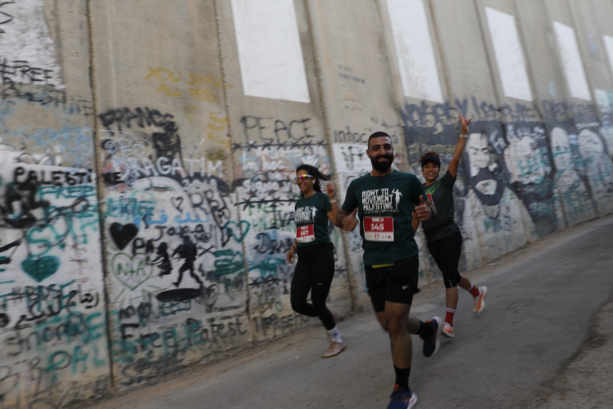 تُظهر الصورة عدائين مشاركين في ماراثون فلسطين الدولي وهم يركضون في شوارع بيت لحم، في مشهد يجمع بين الطابع الرياضي للحدث ورمزيته السياسية والإنسانية المرتبطة بحرية الحركة، 8 مايو/أيار 2026.عدسة: مأمون وزواز.