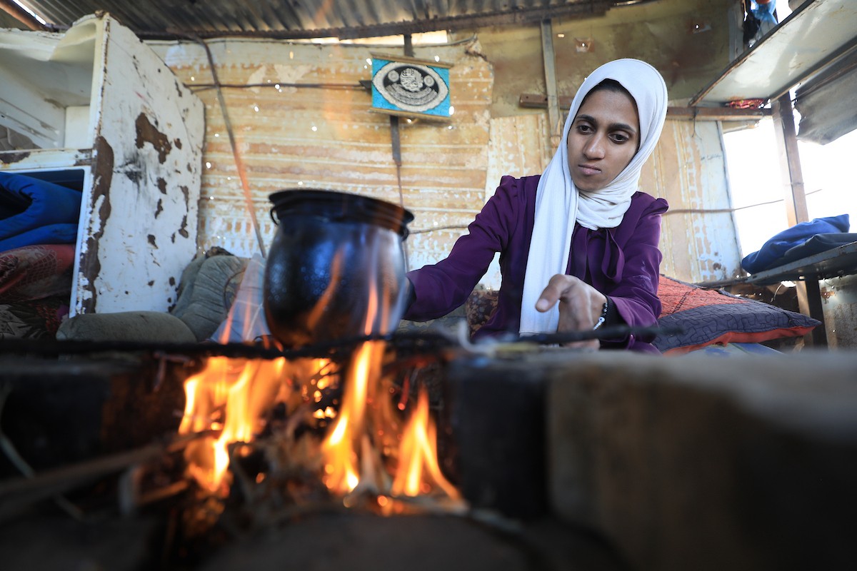 في مخيم البريج وسط قطاع غزة، تعمل الفلسطينية سلامة القريناوي، البالغة من العمر 25 عاماً، في أرض زراعية بتاريخ 7 مايو/أيار 2026، بعدما أجبرتها الحرب على ترك دراستها والبحث عن مصدر رزق لإعالة أسرتها.الصورة: حسن الجديدي