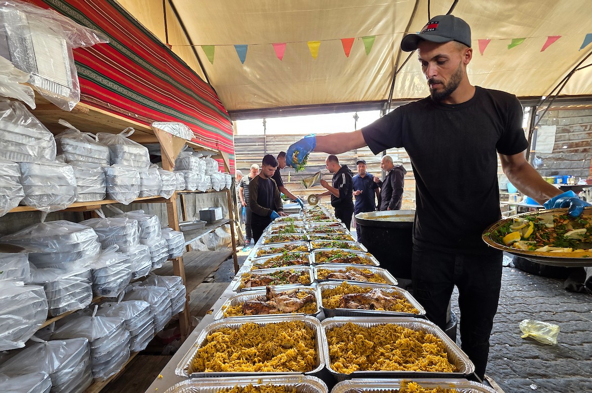 تُظهر الصورة نازحين فلسطينيين متجمعين حول نقطة توزيع طعام في خان يونس جنوب قطاع غزة، حيث ينتظر رجال ونساء وأطفال الحصول على وجبات من مطبخ خيري وسط ظروف إنسانية صعبة،  8 مايو/أيار 2026. عدسة : طارق محمد