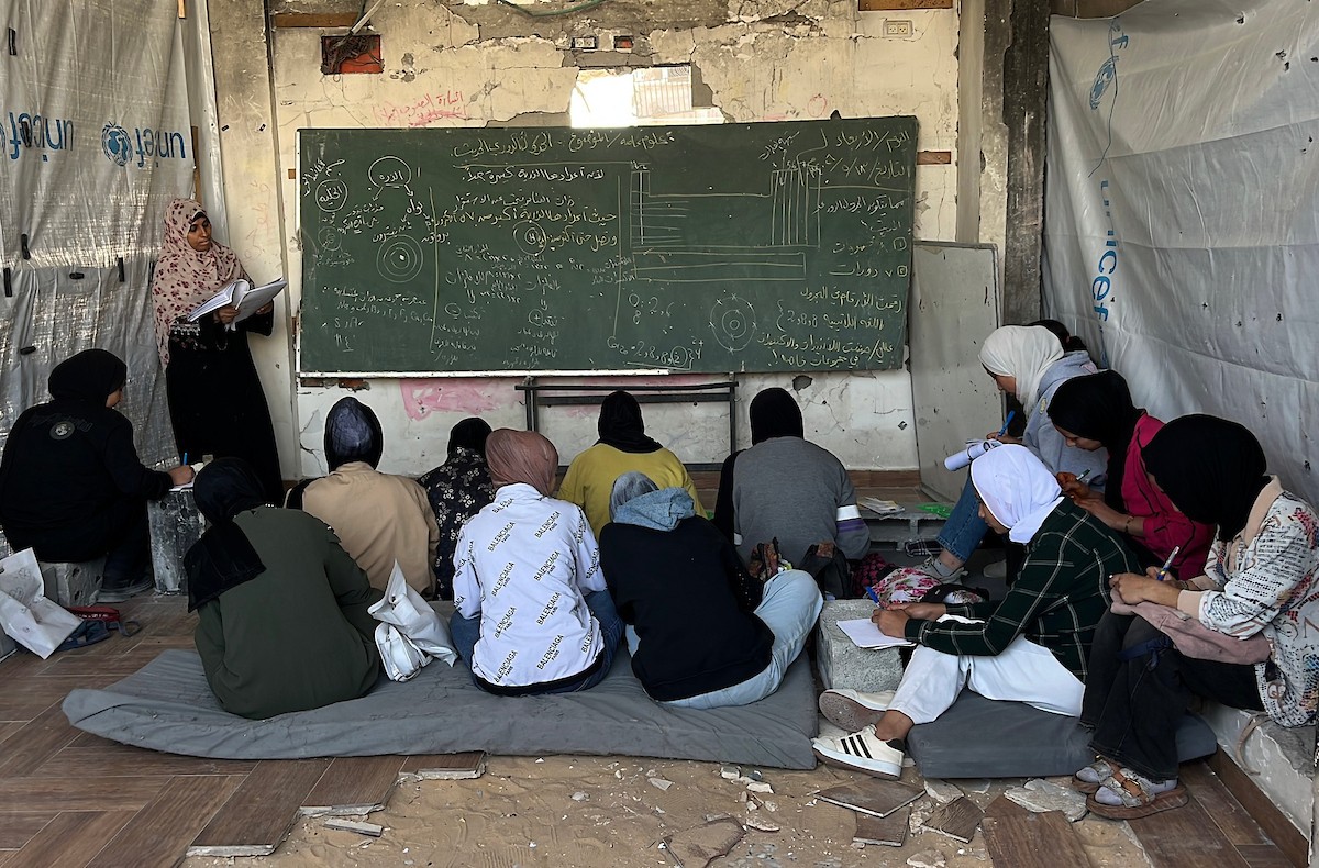 طلاب فلسطينيون يتلقون دروسهم داخل منزل مدمر شرق جباليا شمال قطاع غزة، مستخدمين الحجارة بدل المقاعد، بعد سنوات من الانقطاع عن التعليم بسبب الحرب، 17 أيار/ مايو 2026.تصوير: مطر الزاق