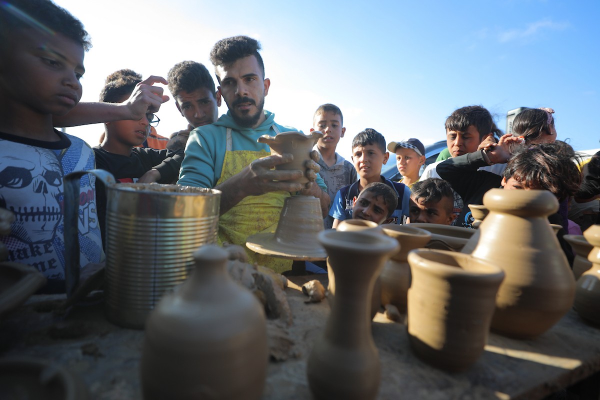 شارك فلسطينيون نازحون في فعالية شعبية بمناسبة عيد العمال العالمي داخل مركز إيواء في مخيم المغازي وسط قطاع غزة، في الأول من مايو/أيار 2026.( تصوير: حسن الجديدي)