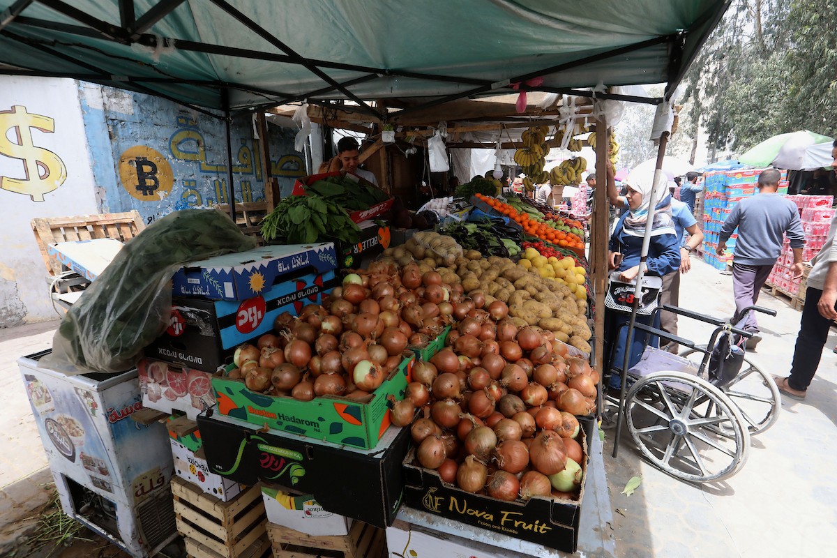 باعة فلسطينيون يعرضون بضائعهم في أكشاك على جانبي شارع الشهداء وسط مدينة غزة، في 12 مايو/أيار 2026، وسط ضعف الطلب الاستهلاكي وتدهور الأوضاع الاقتصادية الناجمة عن الحرب. تصوير: بلال أسامة