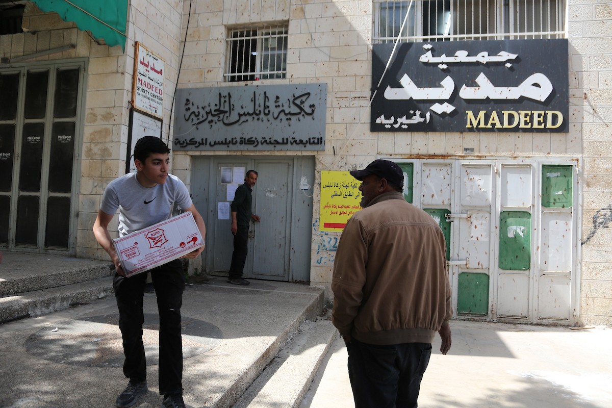 فلسطينيون يتفقدون مكتباً تابعاً لجمعية مديد الخيرية بعد مداهمته من قبل قوات الاحتلال الإسرائيلي وإصدار أمر بإغلاقه فوراً، في مدينة نابلس بالضفة الغربية، في 14 أيار/مايو 2026. تصوير: محمد ناصر.