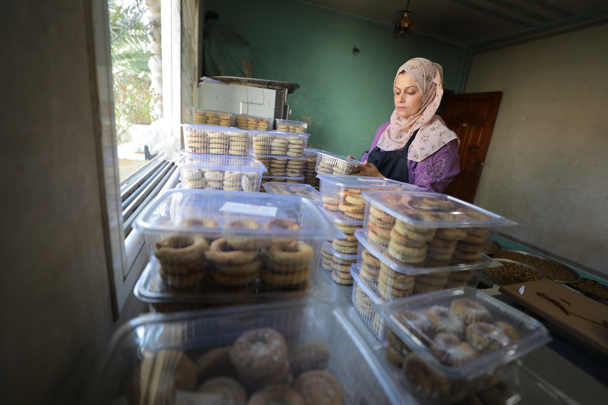 نساء فلسطينيات يُجهّزن كعكات عيد الأضحى التقليدية للبيع في مخيم النصيرات للاجئين وسط قطاع غزة، 25 مايو/أيار 2026. تصوير: حسن الجديدي