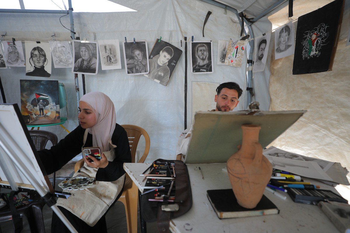 شارك فلسطينيون نازحون في فعالية شعبية بمناسبة عيد العمال العالمي داخل مركز إيواء في مخيم المغازي وسط قطاع غزة، في الأول من مايو/أيار 2026.( تصوير: حسن الجديدي)