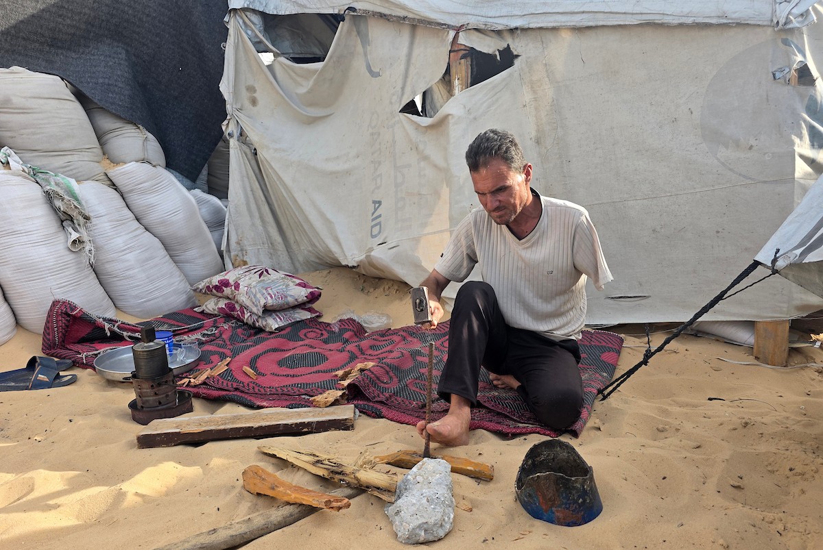 الفلسطيني محمد النواجة، الذي بُترت يده اليسرى في غارة إسرائيلية أثناء فراره من النزوح، يجلس داخل خيمة مهترئة في خان يونس جنوب قطاع غزة، في 18 مايو/أيار 2026، آملاً في الحصول على علاج خارج القطاع وطرف صناعي يساعده على مواصلة حياته. الصورة: طارق محمد