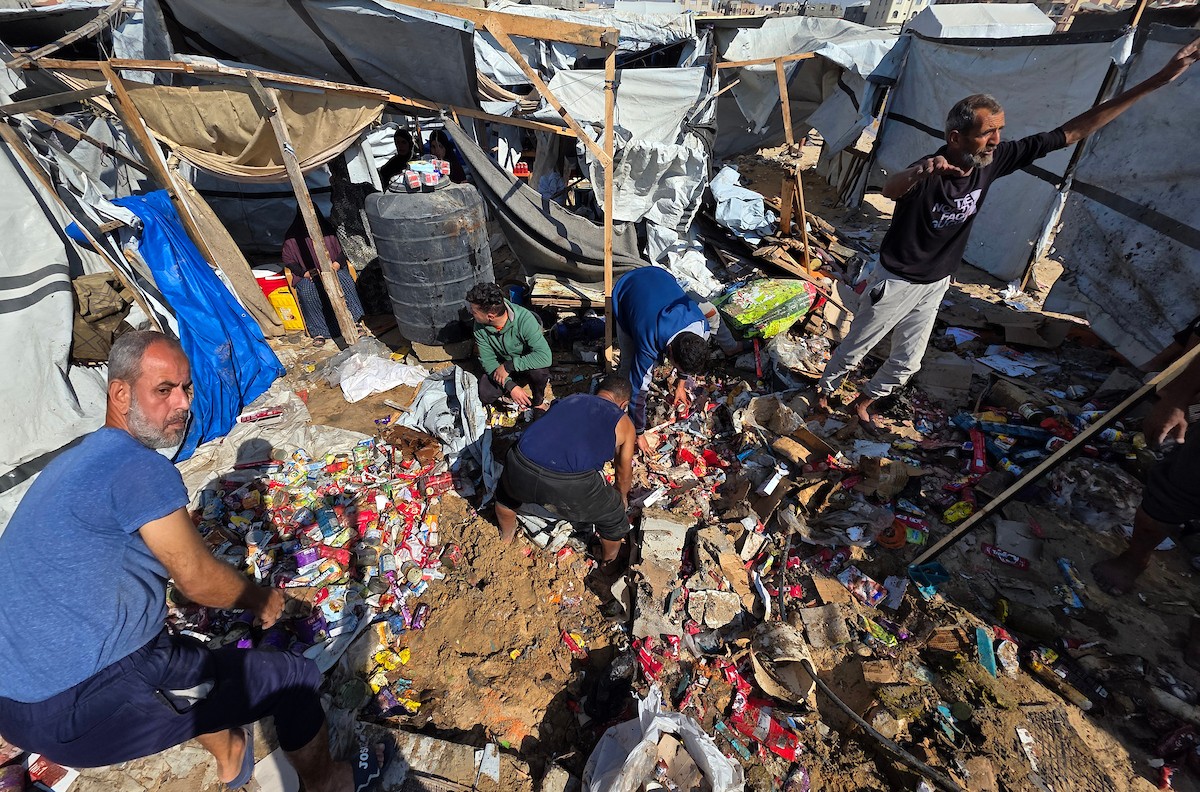 يتفقد مسعفون فلسطينيون وفرق الدفاع المدني وسكان موقع غارة جوية إسرائيلية استهدفت خيمة تأوي نازحين في منطقة مواصي بمحافظة خان يونس جنوب قطاع غزة، في 21 مايو/أيار 2026. صورة: طارق محمد