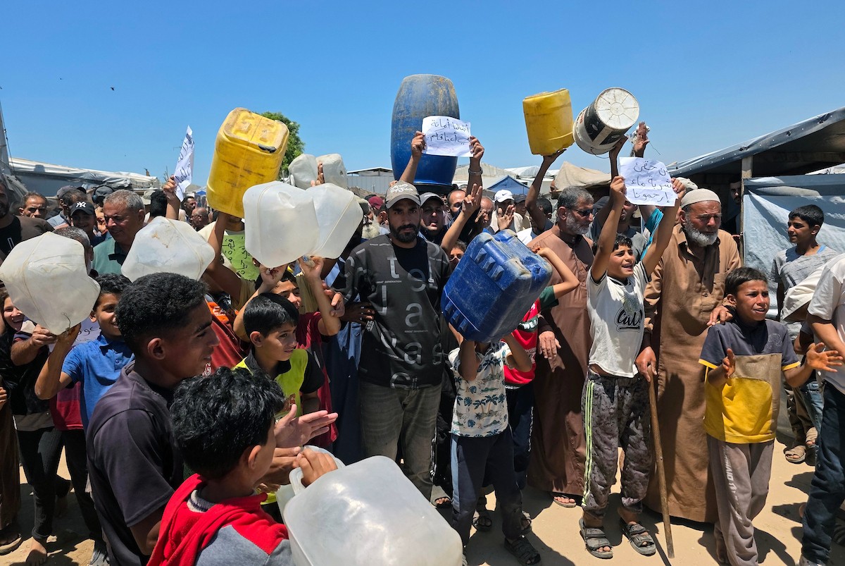 فلسطينيون نازحون يحملون عبوات مياه فارغة خلال احتجاج للمطالبة بتوفير مياه شرب آمنة في خان يونس جنوب قطاع غزة، 25 مايو/أيار 2026. تصوير: طارق محمد