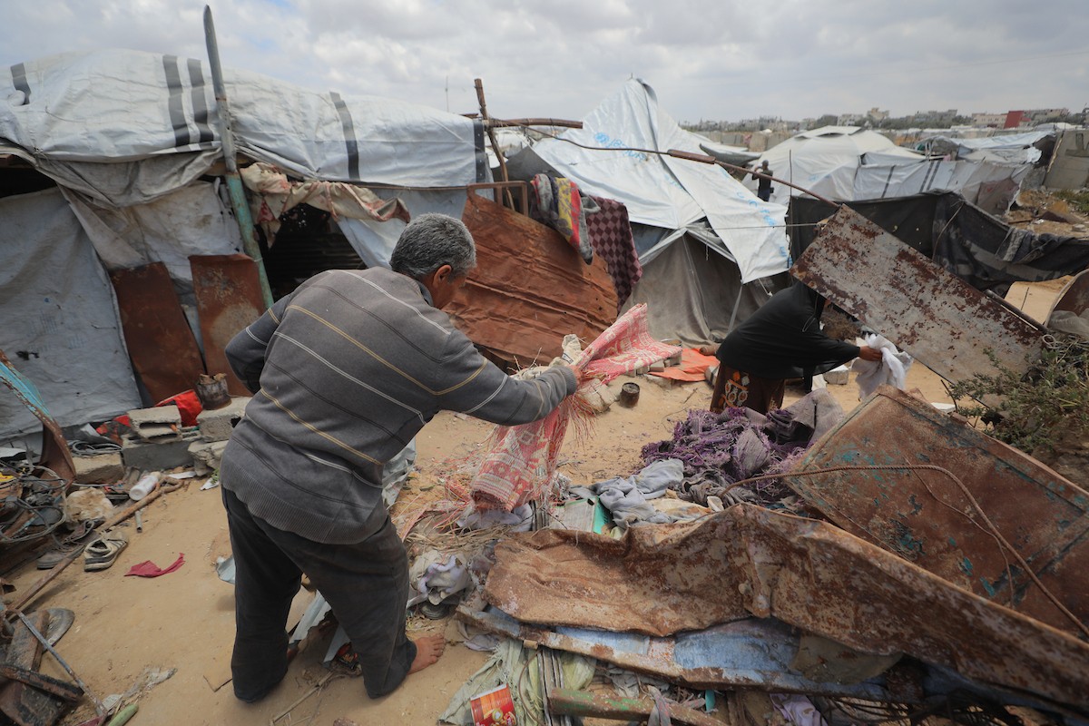 يقضي فلسطينيون نازحون يومهم داخل خيام مهترئة نُصبت بين أنقاض المباني المدمرة في دير البلح وسط قطاع غزة، يوم الإثنين 11 مايو/أيار 2026، في ظل أوضاع إنسانية قاسية وانهيار واسع في مقومات الحياة الأساسية.  (صورة: حسن الجديدي)