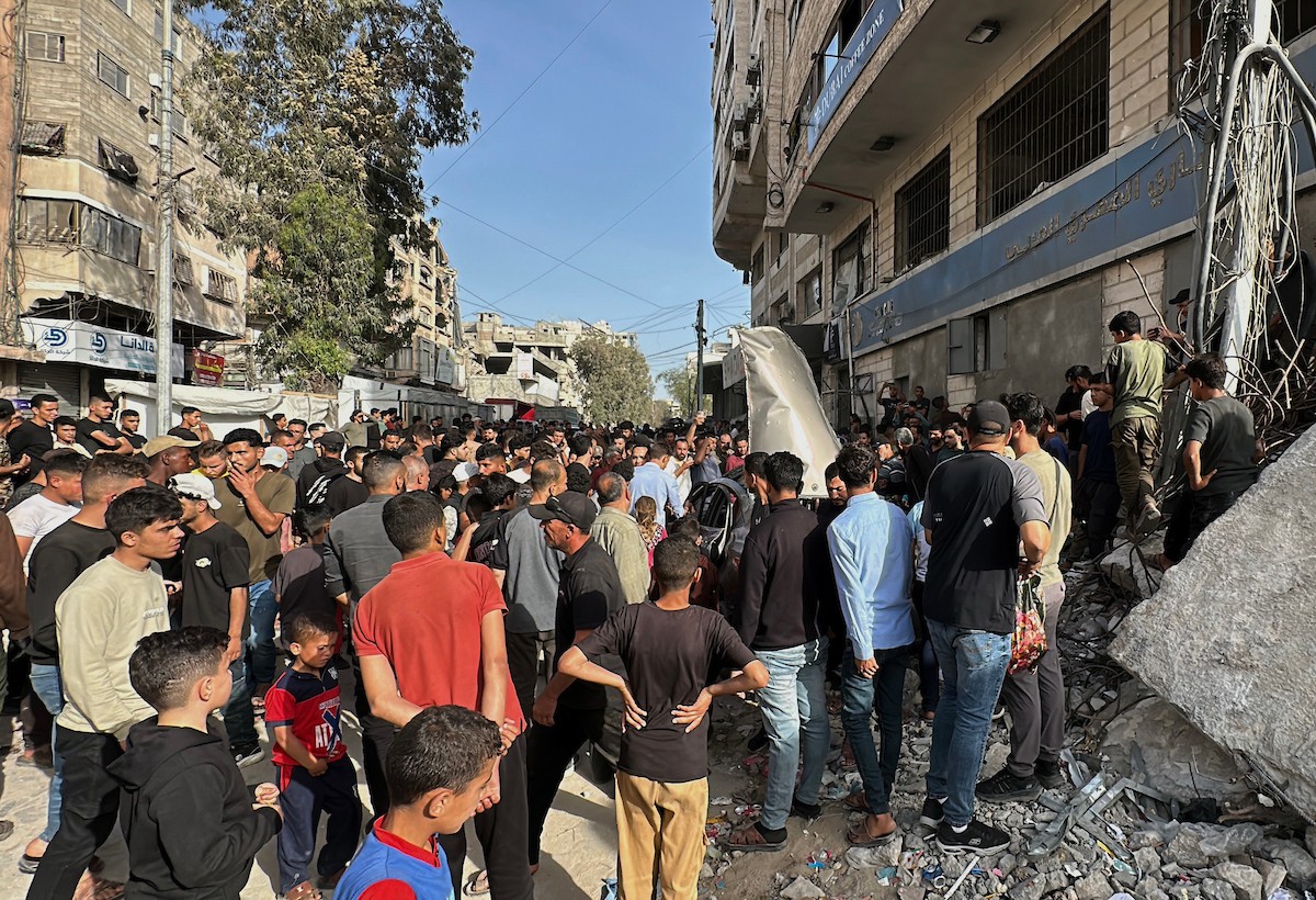 فلسطينيون يتجمعون في موقع غارة جوية إسرائيلية استهدفت مركبة في شارع الشهداء بمدينة غزة، يوم 19 مايو/أيار 2026، وأسفرت، بحسب مصادر محلية، عن استشهاد شخص وإصابة آخرين. تصوير: عمر أشتوي