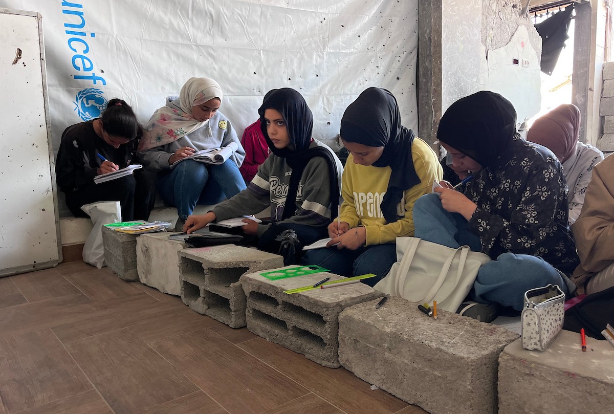 طلاب فلسطينيون يتلقون دروسهم داخل منزل مدمر شرق جباليا شمال قطاع غزة، مستخدمين الحجارة بدل المقاعد، بعد سنوات من الانقطاع عن التعليم بسبب الحرب، 17 أيار/ مايو 2026.تصوير: مطر الزاق