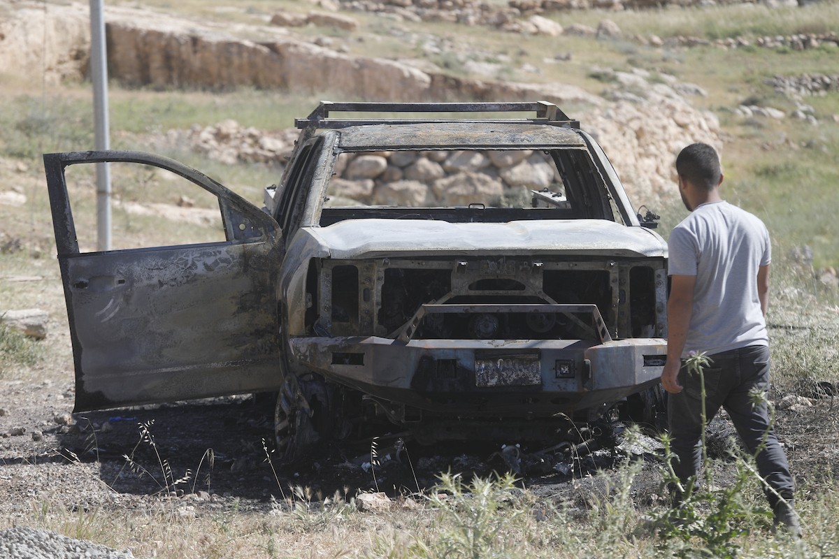 يتفقد فلسطينيون مركبةً تضررت بعد أن أضرم فيها مستوطنون إسرائيليون النار في وادي الرحيم قرب بلدة يطا، جنوب الخليل في الضفة الغربية، في الأول من مايو/أيار 2026.(صورة: مأمون وزواز)