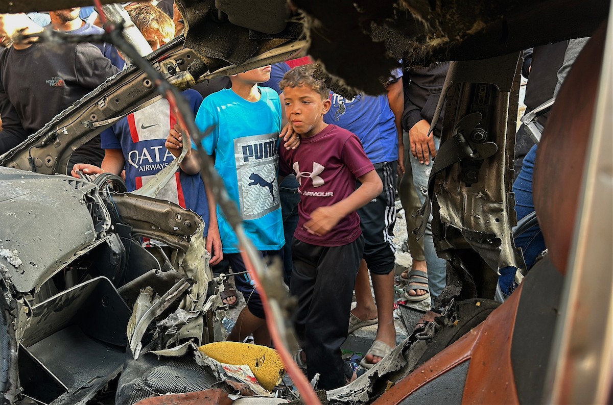 فلسطينيون يتجمعون في موقع غارة جوية إسرائيلية استهدفت مركبة في شارع الشهداء بمدينة غزة، يوم 19 مايو/أيار 2026، وأسفرت، بحسب مصادر محلية، عن استشهاد شخص وإصابة آخرين. تصوير: عمر أشتوي