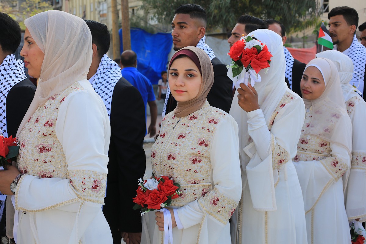 شارك فلسطينيون في مدينة غزة في حفل زفاف جماعي للعرائس والعرسان، نظمته مؤسسة الإغاثة الإنسانية التركية IHH ، 11 مايو/أيار 2026، ضمن مبادرة إنسانية لدعم 50 عريسًا من أبناء الفلسطينيين الذين استشهدوا خلال الحرب.(صورة: بلال أسامة)