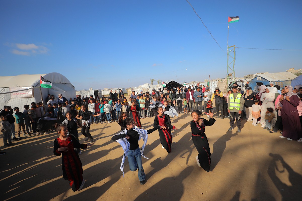 شارك فلسطينيون نازحون في فعالية شعبية بمناسبة عيد العمال العالمي داخل مركز إيواء في مخيم المغازي وسط قطاع غزة، في الأول من مايو/أيار 2026.( تصوير: حسن الجديدي)