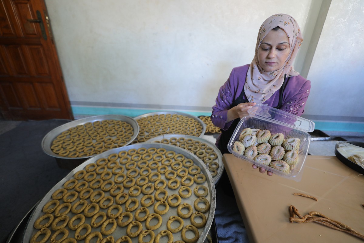 نساء فلسطينيات يُجهّزن كعكات عيد الأضحى التقليدية للبيع في مخيم النصيرات للاجئين وسط قطاع غزة، 25 مايو/أيار 2026. تصوير: حسن الجديدي