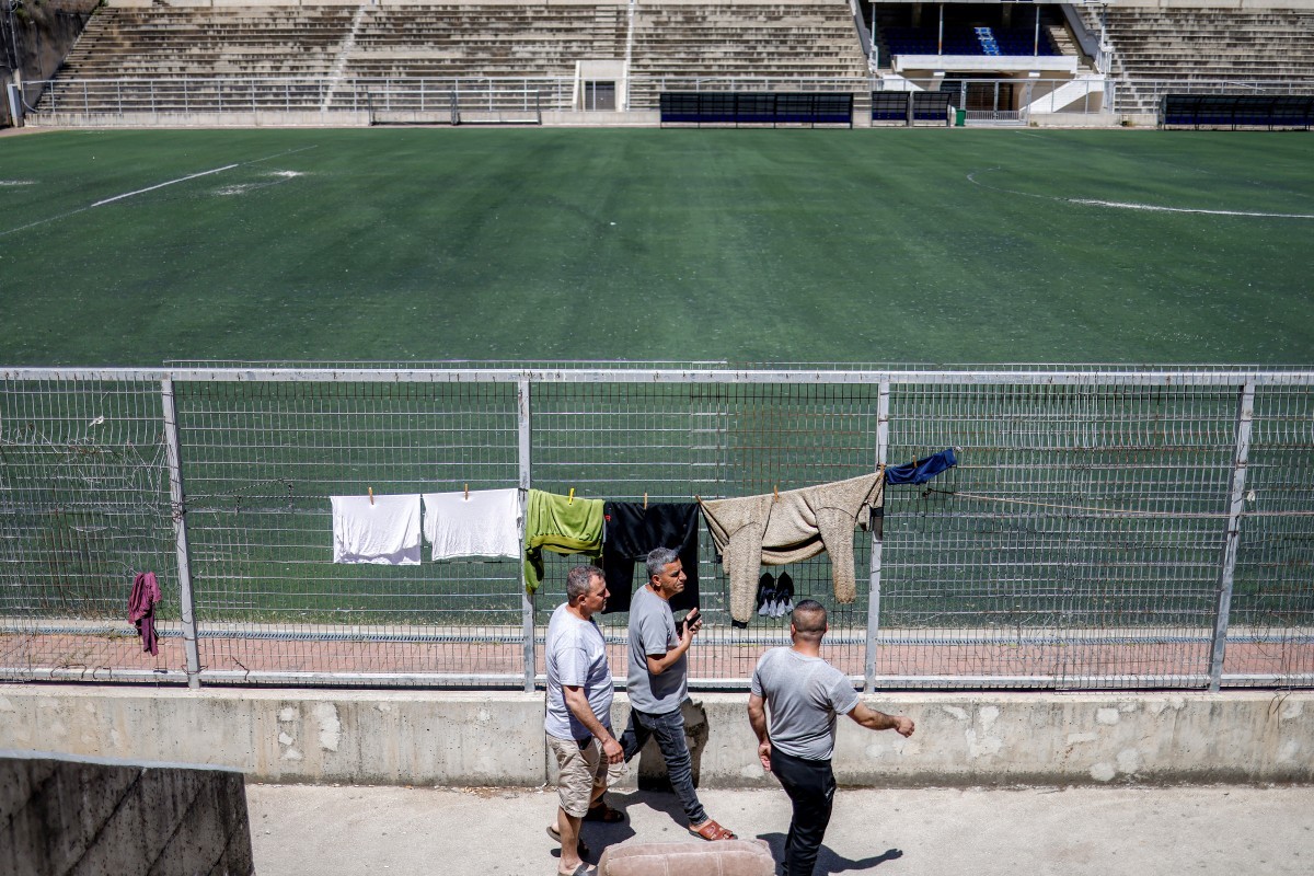 فلسطينيون عالقون من غزة يسيرون بجوار مدرجات ملعب نابلس لكرة القدم وسط مدينة نابلس في الضفة الغربية المحتلة. 7 أيار 2026. (أ ف ب).jpg
