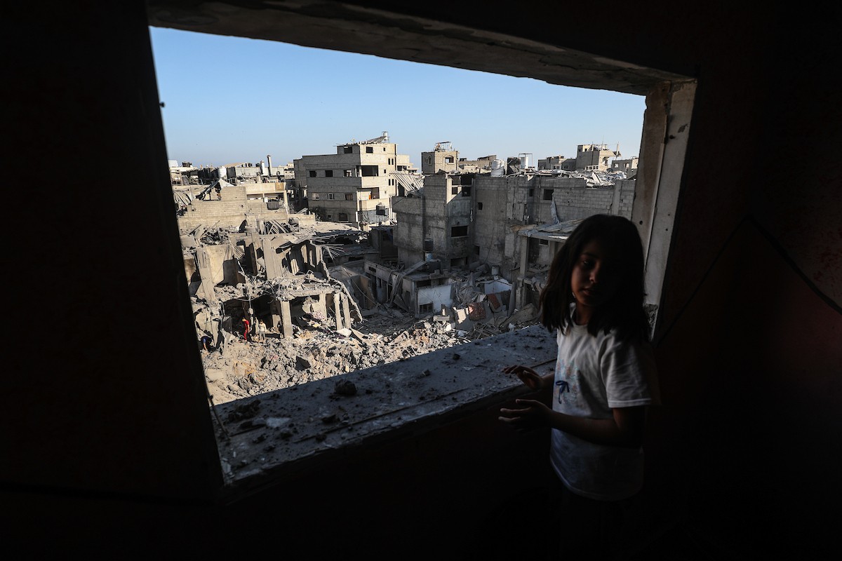 فلسطينيون يتفقدون الأضرار التي لحقت بالمنازل والشوارع عقب غارة إسرائيلية استهدفت منزلاً ومتاجر في مخيم البريج للاجئين وسط قطاع غزة، 23 مايو/أيار 2026. الصورة: معز صالحي