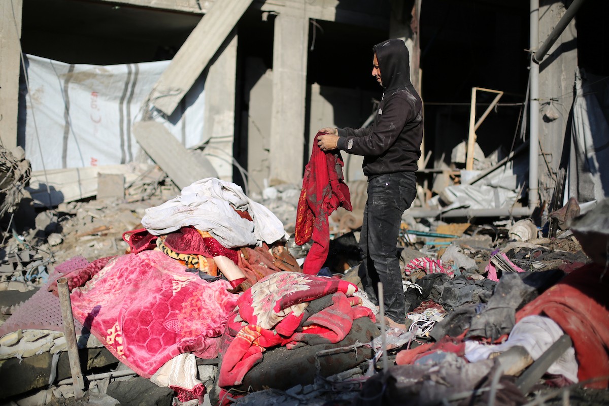 فلسطينيون يتفقدون الأضرار التي لحقت بالمنازل والشوارع عقب غارة إسرائيلية استهدفت منزلاً ومتاجر في مخيم البريج للاجئين وسط قطاع غزة، 23 مايو/أيار 2026. الصورة: معز صالحي