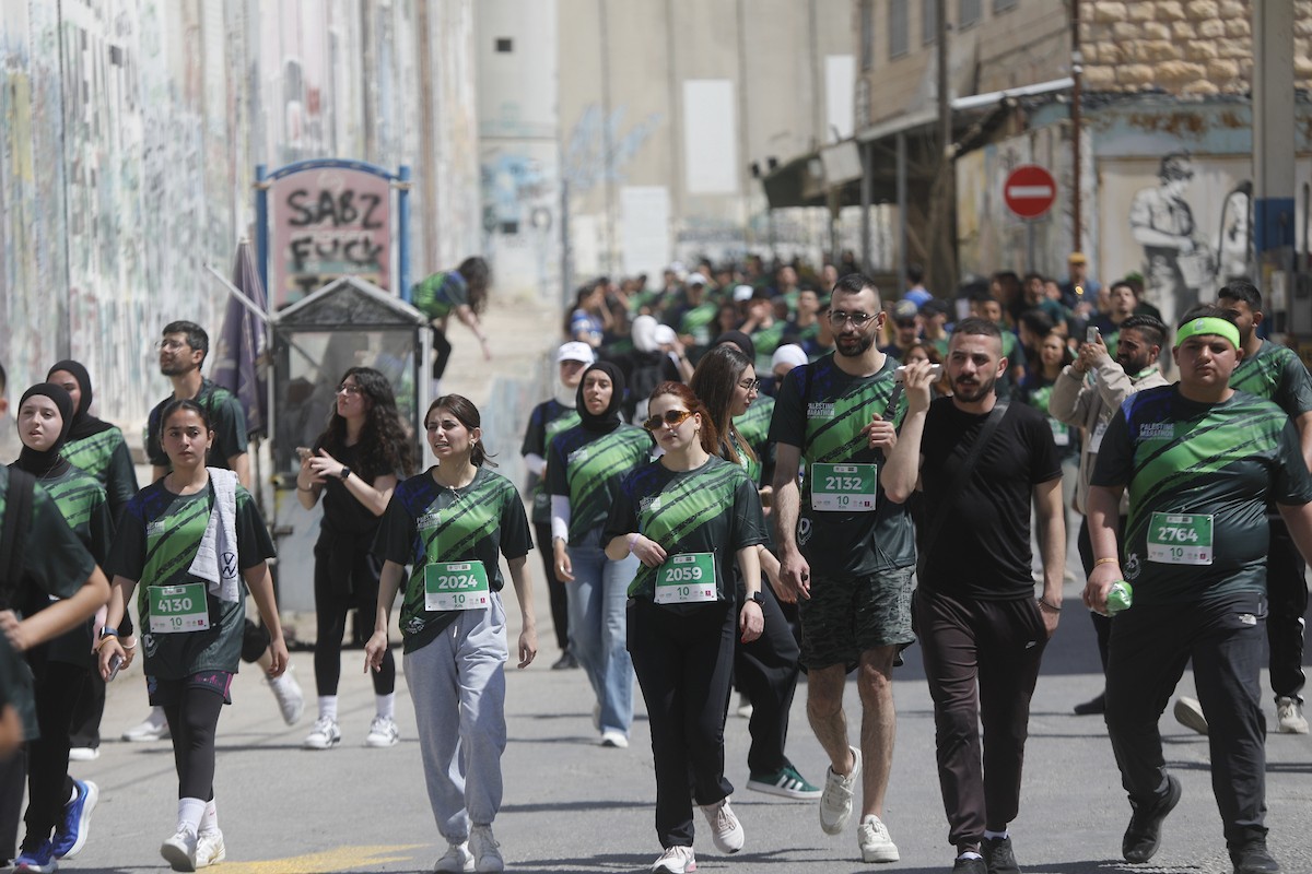 تُظهر الصورة عدائين مشاركين في ماراثون فلسطين الدولي وهم يركضون في شوارع بيت لحم، في مشهد يجمع بين الطابع الرياضي للحدث ورمزيته السياسية والإنسانية المرتبطة بحرية الحركة، 8 مايو/أيار 2026.عدسة: مأمون وزواز.