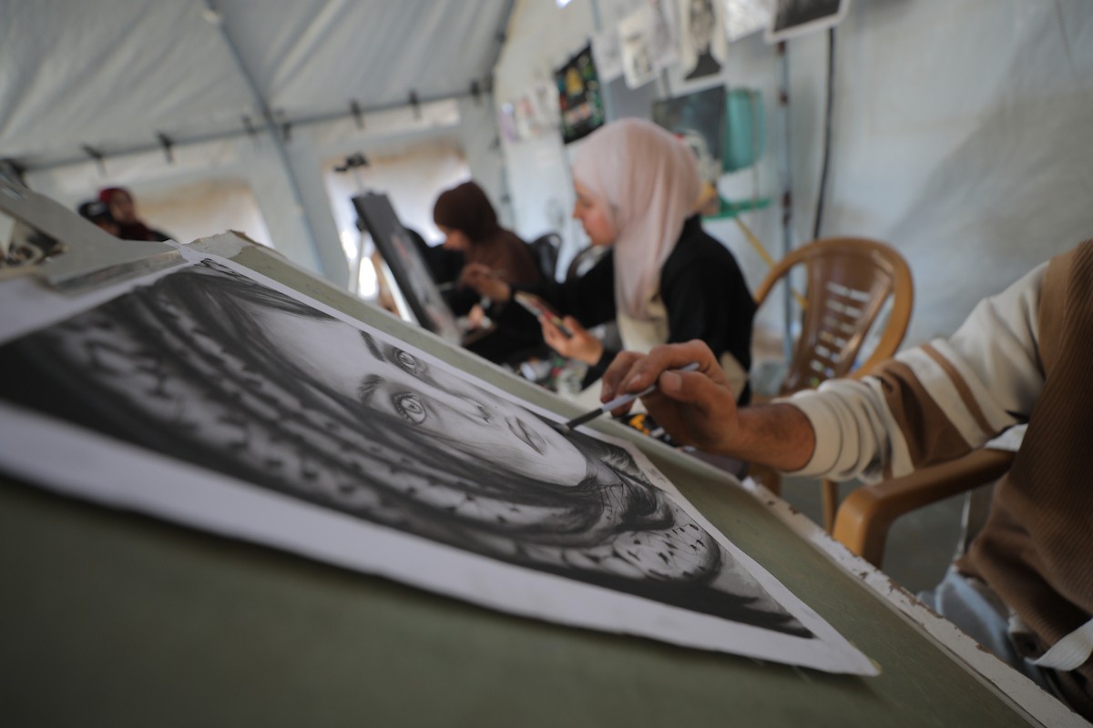 شارك فلسطينيون نازحون في فعالية شعبية بمناسبة عيد العمال العالمي داخل مركز إيواء في مخيم المغازي وسط قطاع غزة، في الأول من مايو/أيار 2026.( تصوير: حسن الجديدي)