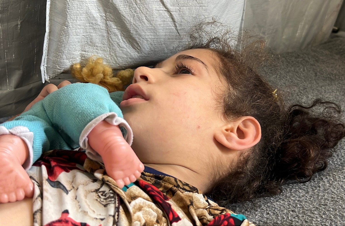 الطفلة داليا الزويدي تتلقى الرعاية من والديها داخل خيمة نزوحهم في مخيم النصيرات، تعاني داليا من نقص الأكسجين وسوء التغذية وسط تدهور الأوضاع الصحية ونقص الغذاء والدواء في القطاع، 10 أيار/ مايو 2026.(صورة: يوسف أبو وطفة)