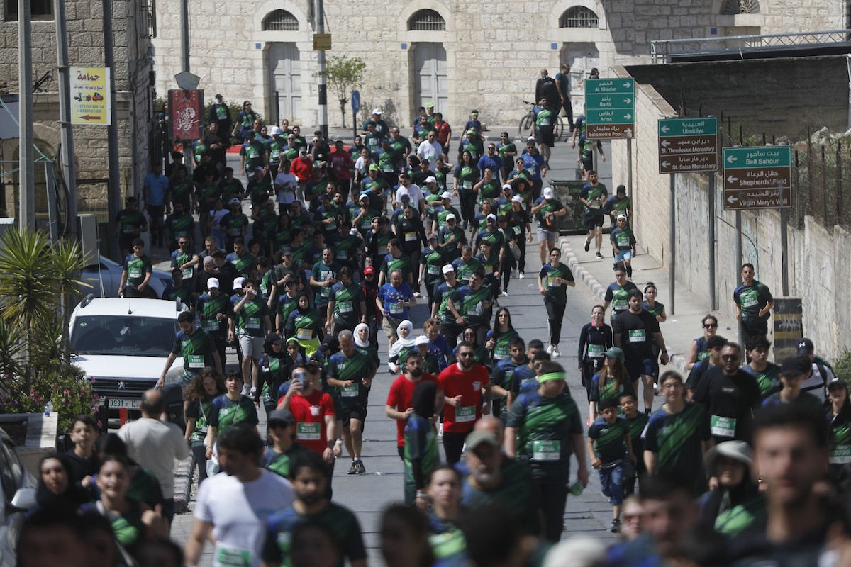 تُظهر الصورة عدائين مشاركين في ماراثون فلسطين الدولي وهم يركضون في شوارع بيت لحم، في مشهد يجمع بين الطابع الرياضي للحدث ورمزيته السياسية والإنسانية المرتبطة بحرية الحركة، 8 مايو/أيار 2026.عدسة: مأمون وزواز.