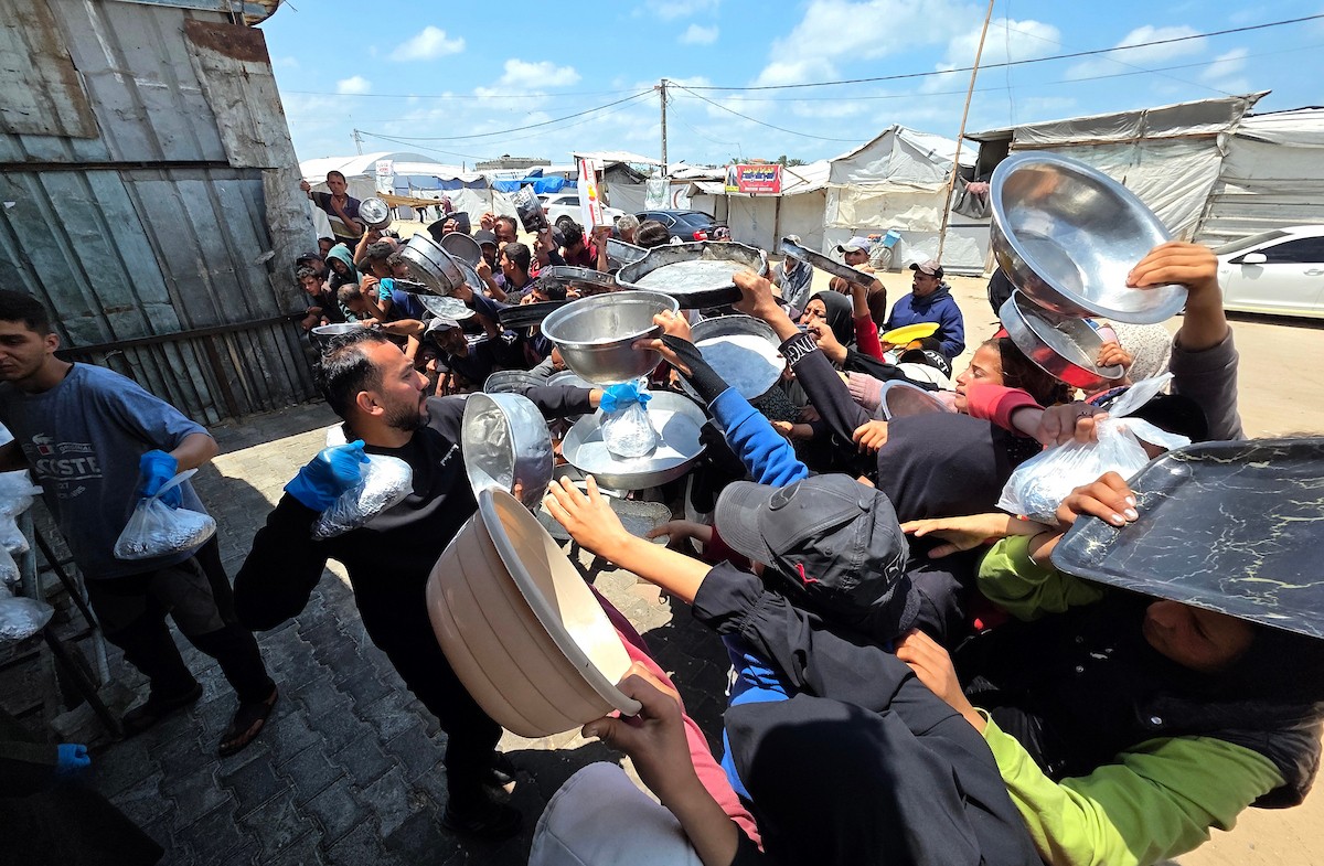 تُظهر الصورة نازحين فلسطينيين متجمعين حول نقطة توزيع طعام في خان يونس جنوب قطاع غزة، حيث ينتظر رجال ونساء وأطفال الحصول على وجبات من مطبخ خيري وسط ظروف إنسانية صعبة،  8 مايو/أيار 2026. عدسة : طارق محمد