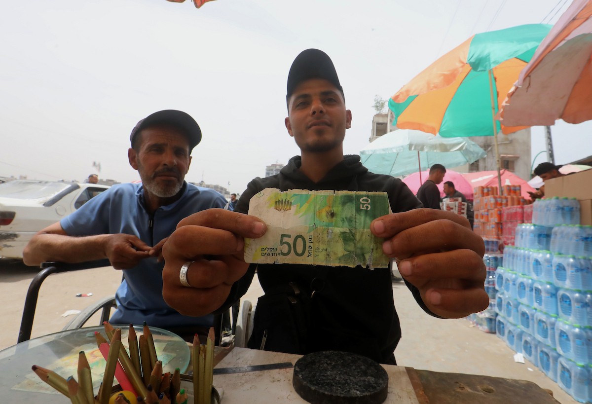 باعة فلسطينيون يعرضون بضائعهم في أكشاك على جانبي شارع الشهداء وسط مدينة غزة، في 12 مايو/أيار 2026، وسط ضعف الطلب الاستهلاكي وتدهور الأوضاع الاقتصادية الناجمة عن الحرب. تصوير: بلال أسامة