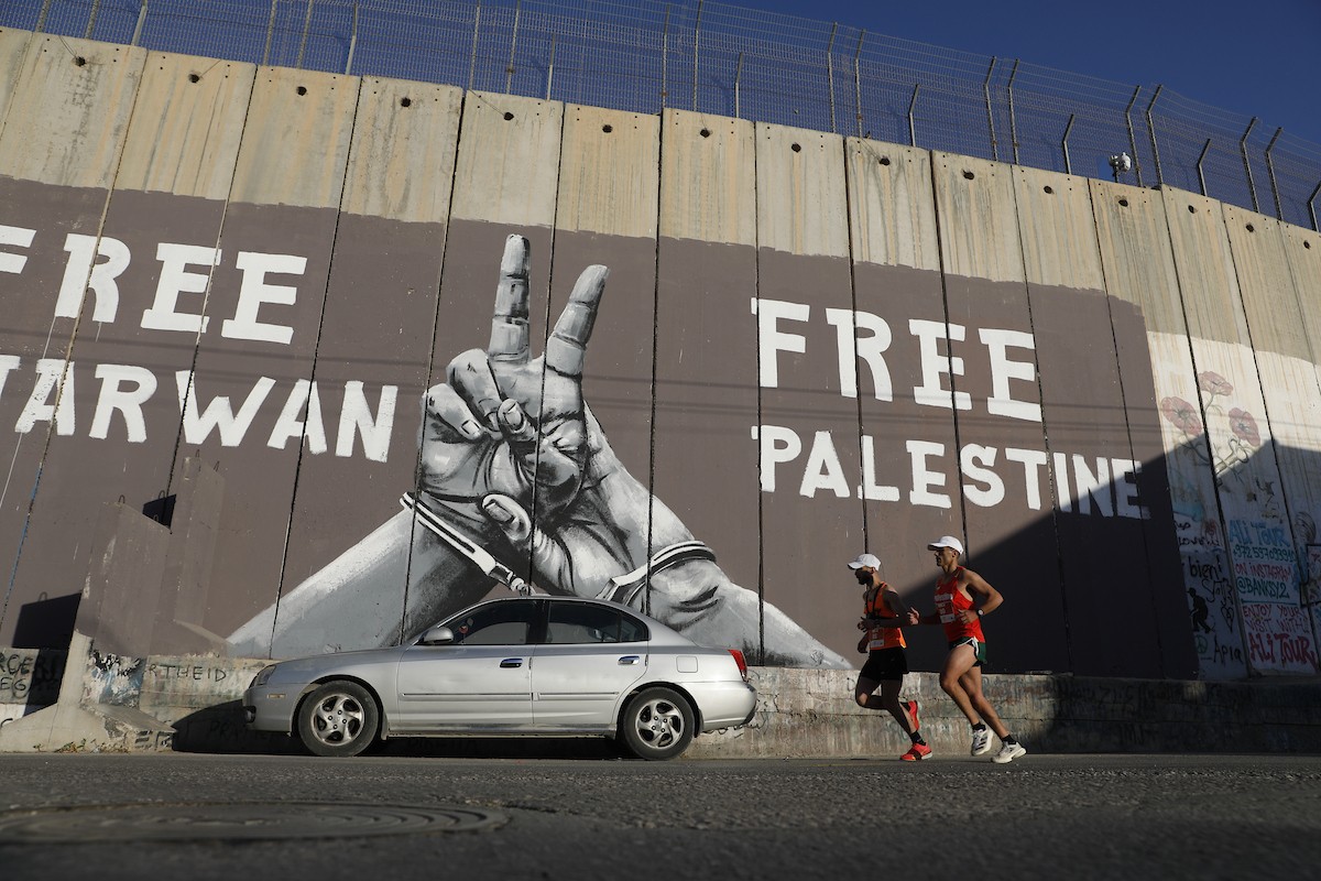 تُظهر الصورة عدائين مشاركين في ماراثون فلسطين الدولي وهم يركضون في شوارع بيت لحم، في مشهد يجمع بين الطابع الرياضي للحدث ورمزيته السياسية والإنسانية المرتبطة بحرية الحركة، 8 مايو/أيار 2026.عدسة: مأمون وزواز.