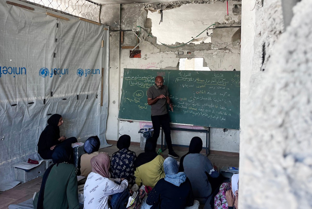 طلاب فلسطينيون يتلقون دروسهم داخل منزل مدمر شرق جباليا شمال قطاع غزة، مستخدمين الحجارة بدل المقاعد، بعد سنوات من الانقطاع عن التعليم بسبب الحرب، 17 أيار/ مايو 2026.تصوير: مطر الزاق