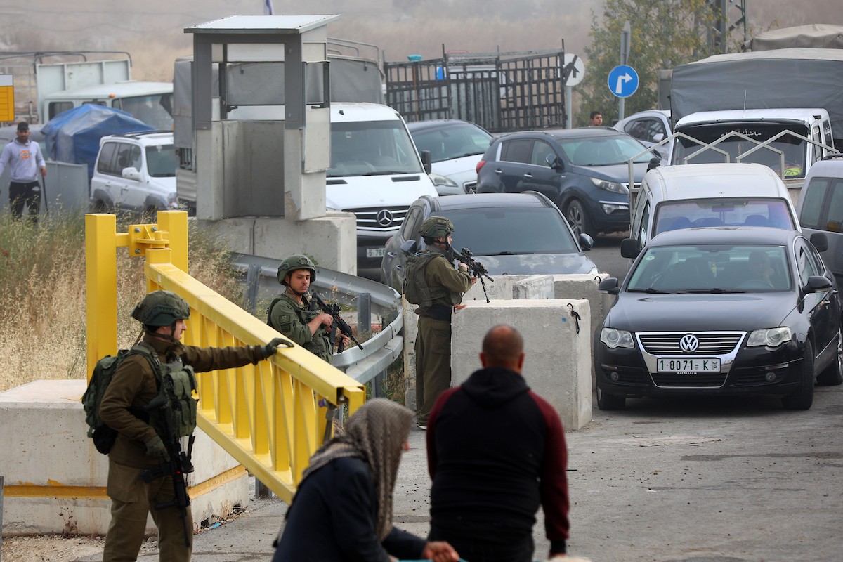 فلسطينيون يعبرون نقاط تفتيش أقامها جنود إسرائيليون بحواجز حديدية للوصول إلى سوق الحلال في الخليل، جنوب الضفة الغربية المحتلة، قبيل عيد الأضحى، في 22 أيار/مايو 2026. تصوير: مأمون وزواز.
