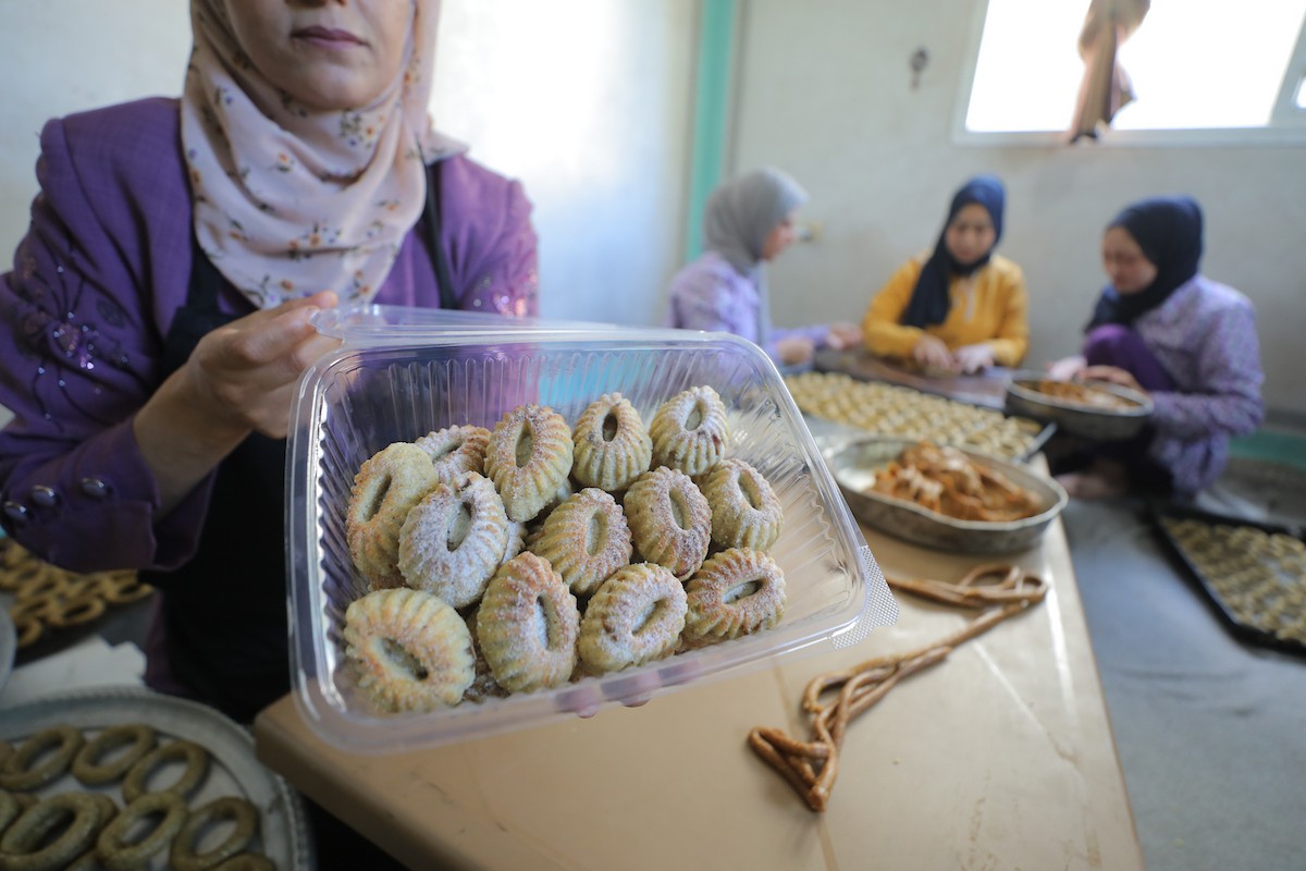 نساء فلسطينيات يُجهّزن كعكات عيد الأضحى التقليدية للبيع في مخيم النصيرات للاجئين وسط قطاع غزة، 25 مايو/أيار 2026. تصوير: حسن الجديدي