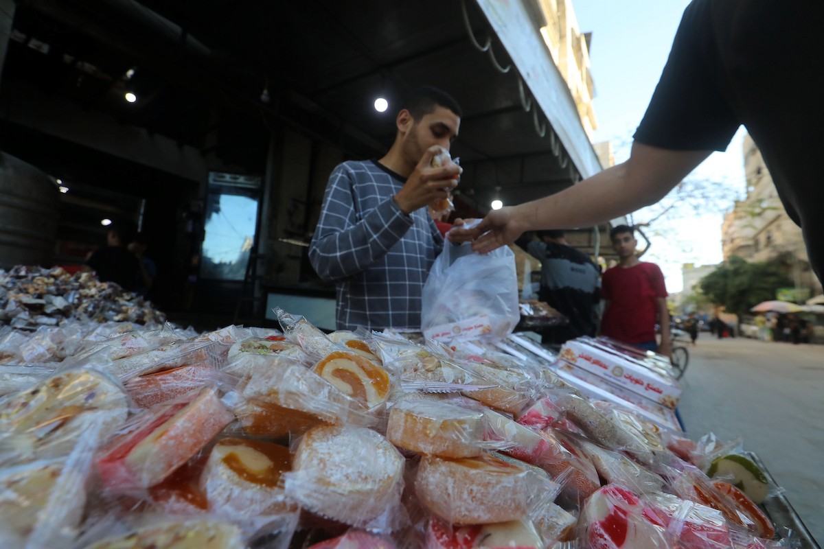 عمال فلسطينيون ينتجون حلوى “الحلقوم” التقليدية داخل مصنع متضرر في حي الدرج شرق مدينة غزة، قبيل عيد الأضحى المبارك، في 24 أيار/مايو 2026، بعد استئناف العمل بإمكانيات محدودة جراء أضرار الحرب وتراجع القدرة الشرائية للسكان. تصوير: بلال أسامة