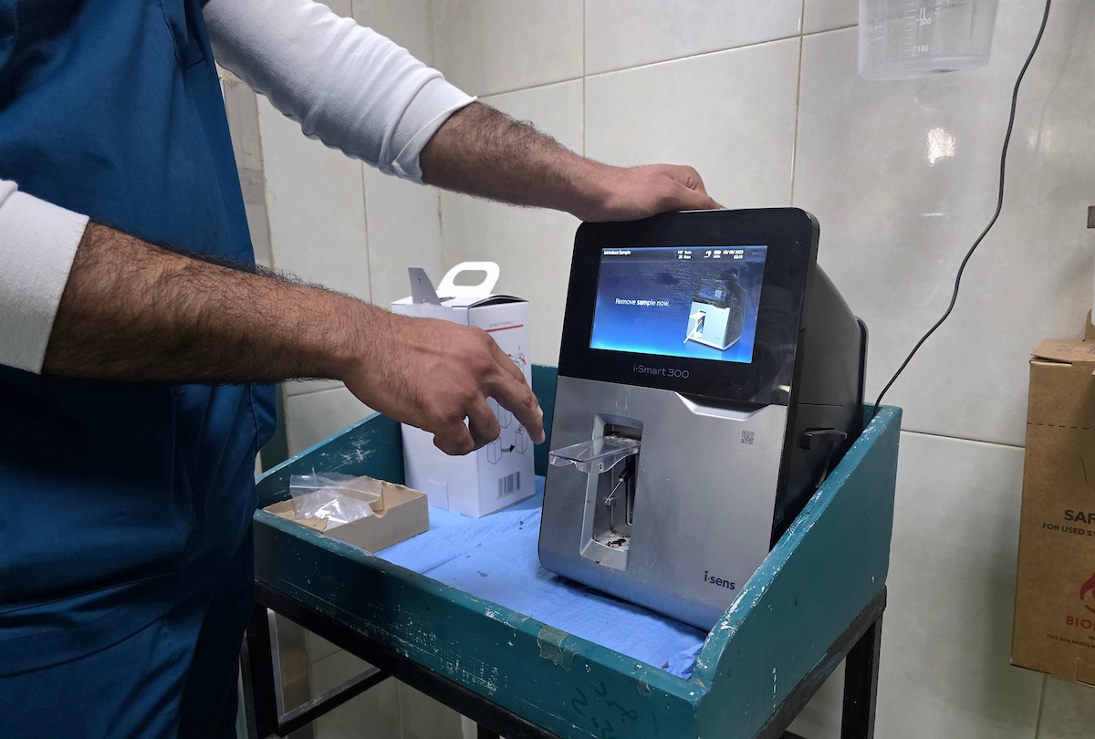أجرى أطباء فلسطينيون فحوصات محدودة على عينات مرضى داخل مختبر طبي في مجمع ناصر الطبي بخان يونس، جنوب قطاع غزة، في 6 مايو/أيار 2026، وسط نقص واضح في المعدات والمستلزمات الطبية (صورة: طارق محمد)
