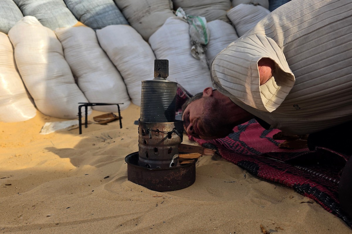 الفلسطيني محمد النواجة، الذي بُترت يده اليسرى في غارة إسرائيلية أثناء فراره من النزوح، يجلس داخل خيمة مهترئة في خان يونس جنوب قطاع غزة، في 18 مايو/أيار 2026، آملاً في الحصول على علاج خارج القطاع وطرف صناعي يساعده على مواصلة حياته. الصورة: طارق محمد