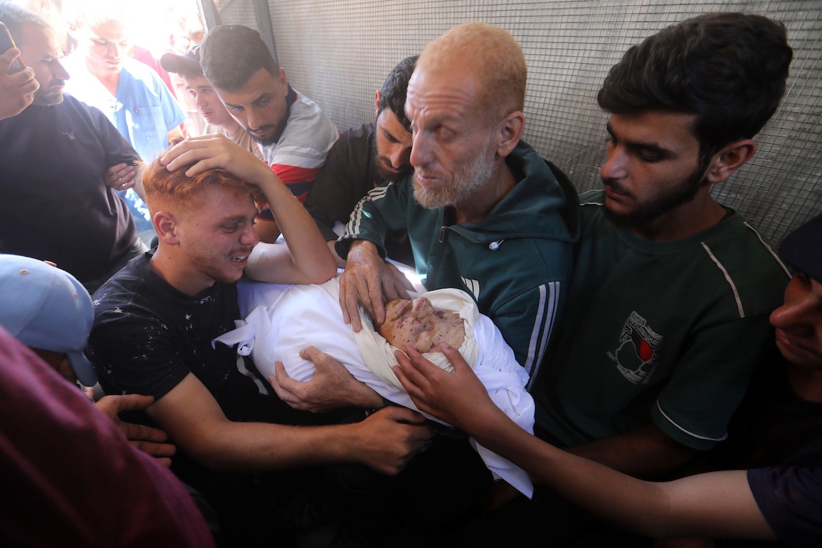 فلسطينيون ينوحون على جثمان شاب في مستشفى الشفاء بمدينة غزة في 24 مايو/أيار 2026، بعد استشهاده بنيران قناص إسرائيلي في جباليا شمال قطاع غزة. (صورة: بلال أسامة)