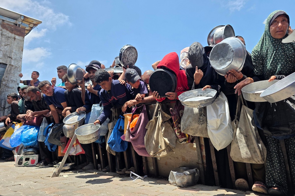 تُظهر الصورة نازحين فلسطينيين متجمعين حول نقطة توزيع طعام في خان يونس جنوب قطاع غزة، حيث ينتظر رجال ونساء وأطفال الحصول على وجبات من مطبخ خيري وسط ظروف إنسانية صعبة،  8 مايو/أيار 2026. عدسة : طارق محمد