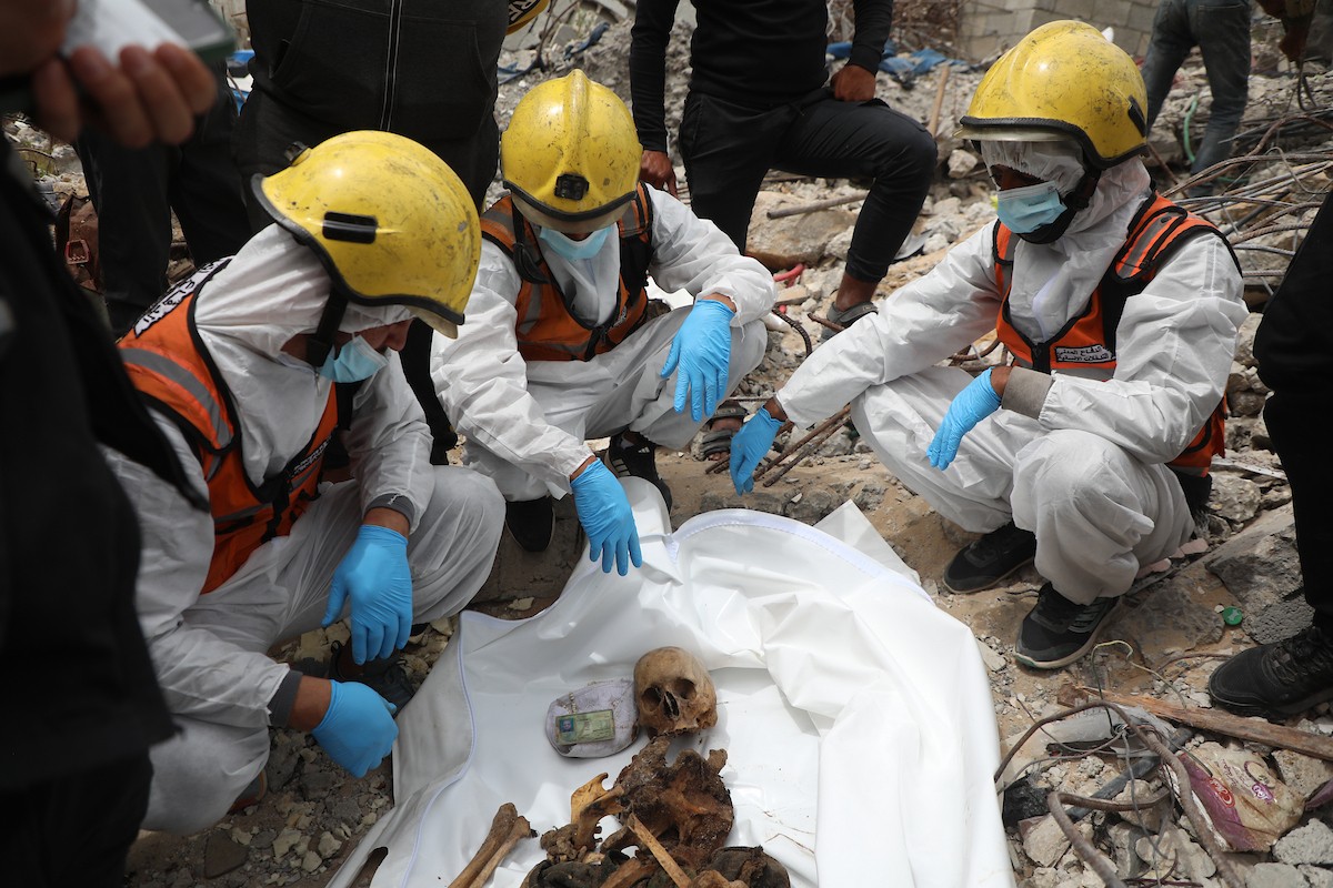 أفراد من عائلة خلة الفلسطينية ينتشلون رفات ضحيتين من تحت أنقاض منزلهم المدمر في منطقة جباليا النزلة شمال قطاع غزة، في 12 مايو/أيار 2026، بعد أكثر من عامين ونصف من استهداف المنزل خلال العمليات العسكرية الإسرائيلية. ولا تزال رفات أكثر من 25 شخصاً يُعتقد أنها عالقة تحت الركام. تصوير: عمر أشتوي