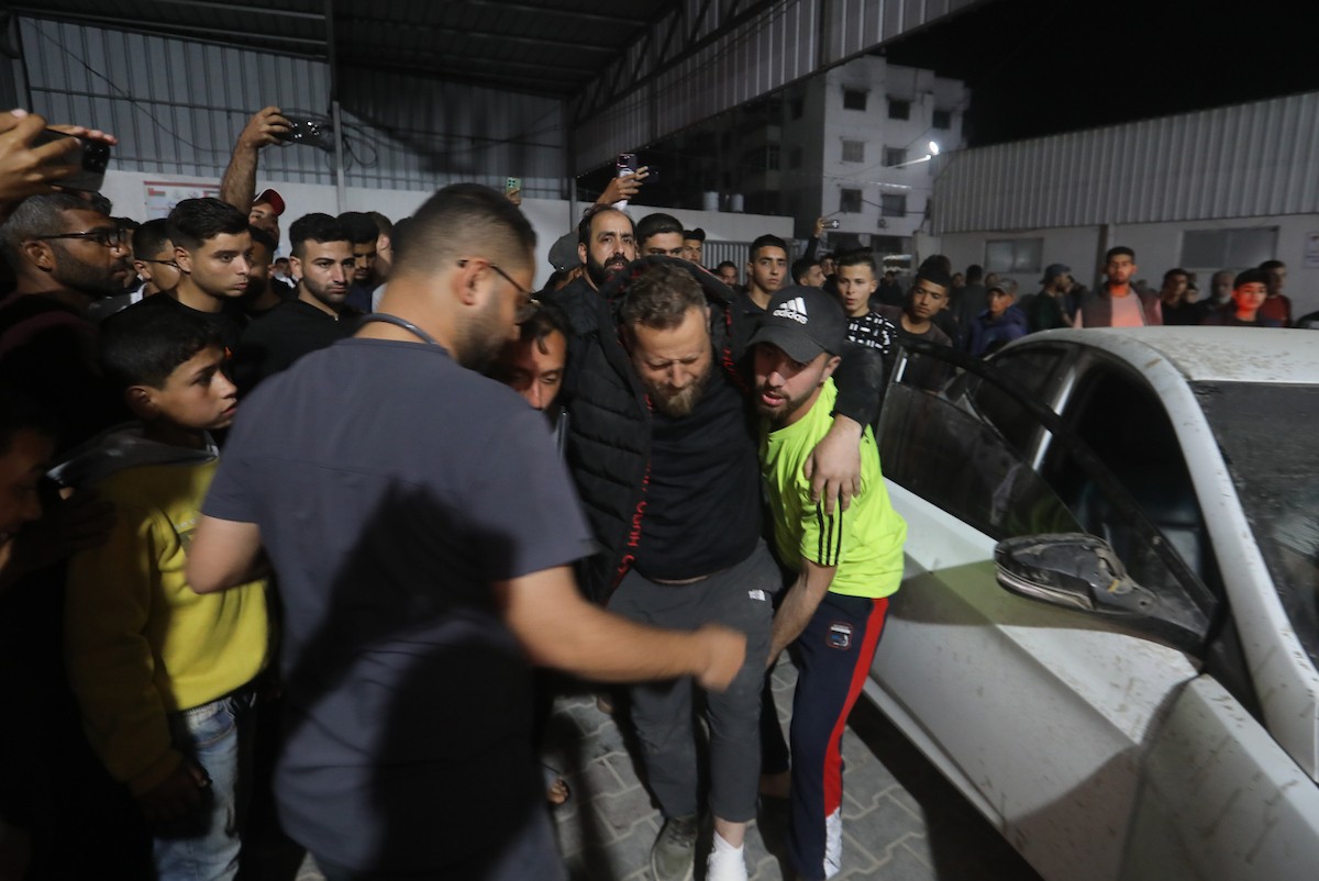 فلسطينيون ينقلون جرحى وقتلى إلى مستشفى الشفاء عقب غارة جوية إسرائيلية استهدفت مبنى سكنياً في حي الرمال بمدينة غزة، في 15 مايو/أيار 2026. وأسفرت الغارة عن سقوط ضحايا، بحسب معلومات محلية. صورة: بلال أسامة.