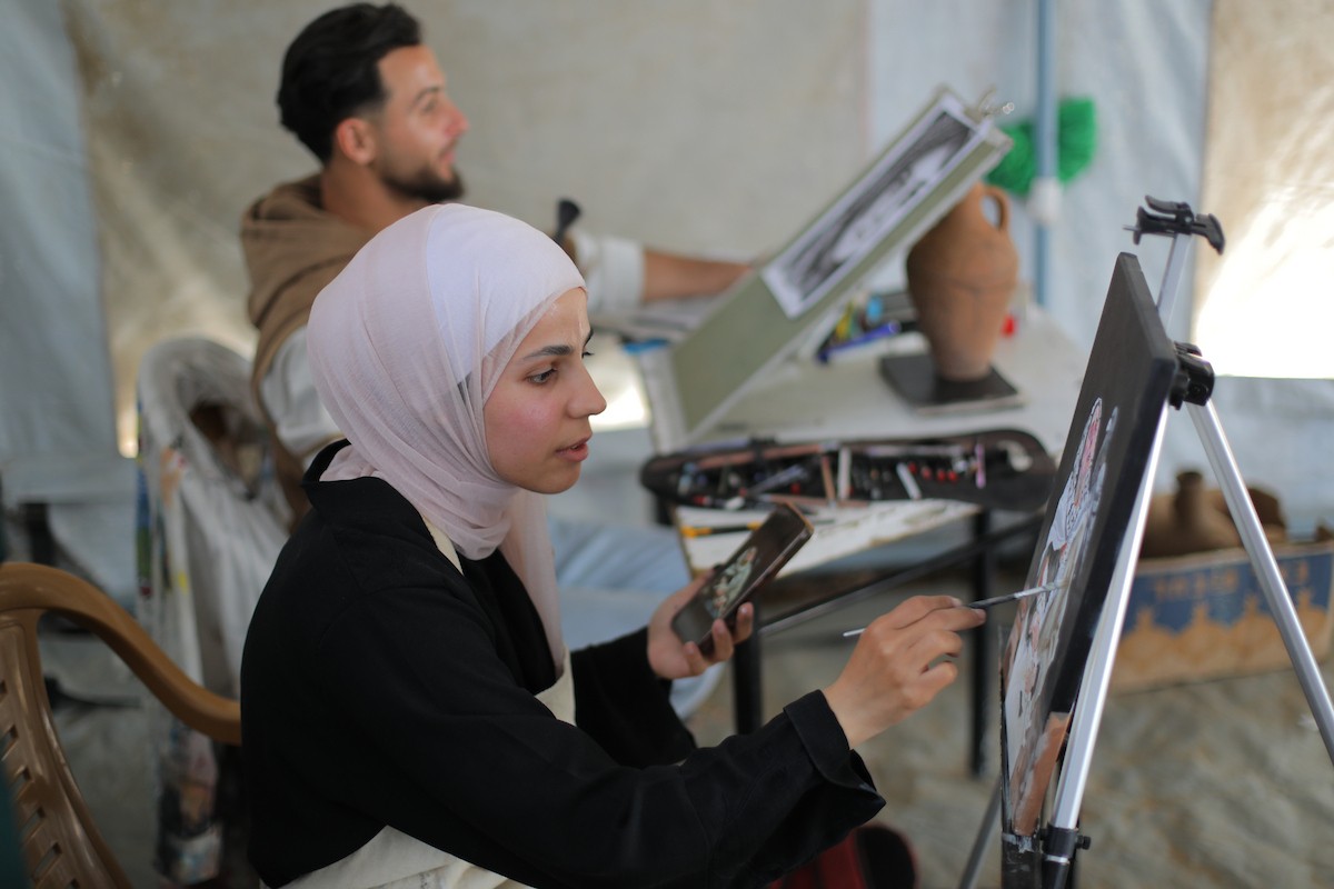 شارك فلسطينيون نازحون في فعالية شعبية بمناسبة عيد العمال العالمي داخل مركز إيواء في مخيم المغازي وسط قطاع غزة، في الأول من مايو/أيار 2026.( تصوير: حسن الجديدي)