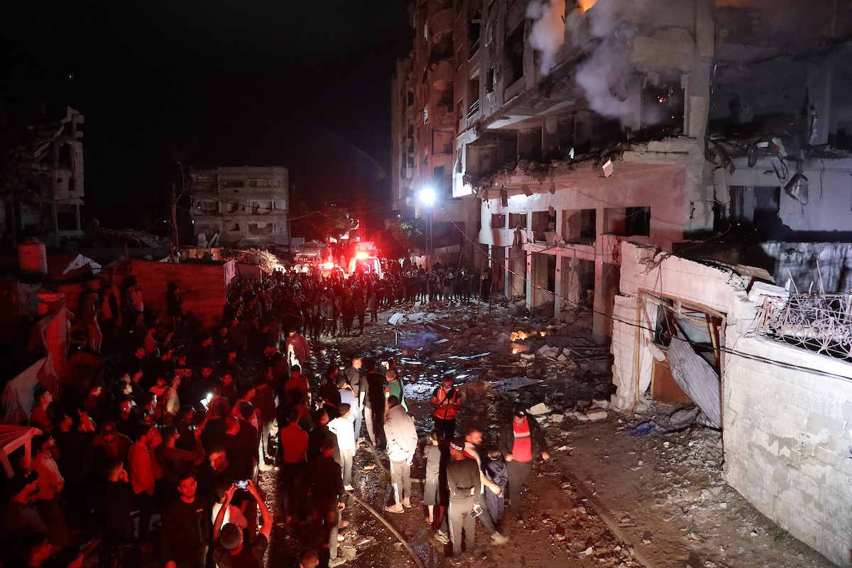 تجمع الناس حول مبنى سكني بينما اندلع حريق في مدينة غزة عقب قصف إسرائيلي، وفقاً لوزارة الصحة، في 15 مايو/أيار 2026. صورة: عمر أشتوي.