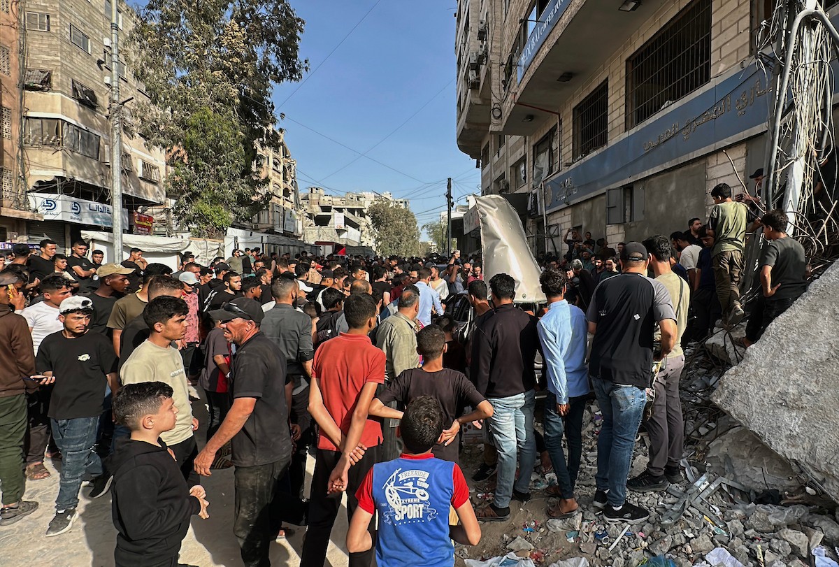 فلسطينيون يتجمعون في موقع غارة جوية إسرائيلية استهدفت مركبة في شارع الشهداء بمدينة غزة، يوم 19 مايو/أيار 2026، وأسفرت، بحسب مصادر محلية، عن استشهاد شخص وإصابة آخرين. تصوير: عمر أشتوي